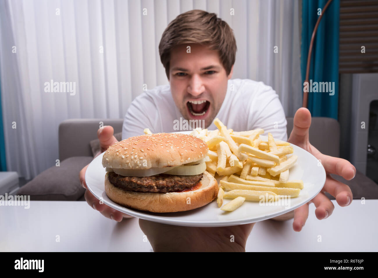 L'homme prenant la malbouffe On Plate Banque D'Images
