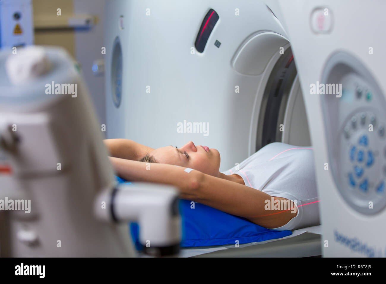 Jolie jeune femme goiing à travers une tomodensitométrie (CAT) Scan test/examen médical dans un hôpital moderne aux tons de couleur peu profondes de l'image (DOF) Banque D'Images