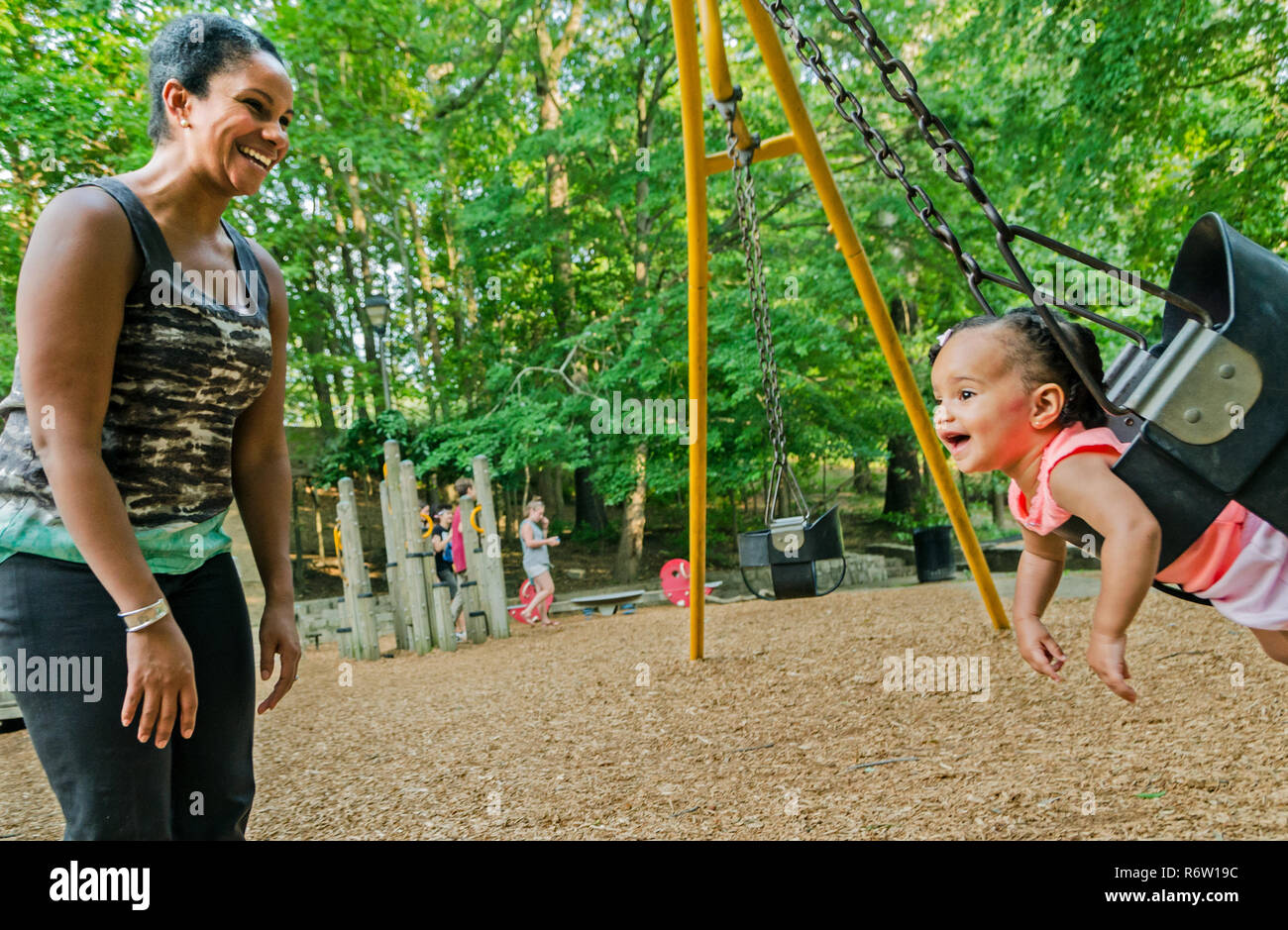 Nailah Wagner pousse sa fille, 10 mois, Emery Wagner, dans une balançoire à Candler Park, le 4 juin 2014, à Atlanta, Géorgie. Banque D'Images