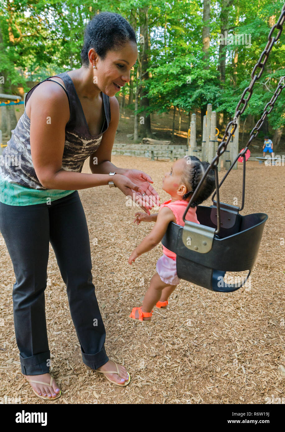 Nailah Wagner pousse sa fille, 10 mois, Emery Wagner, dans une balançoire à Candler Park, le 4 juin 2014, à Atlanta, Géorgie. Banque D'Images