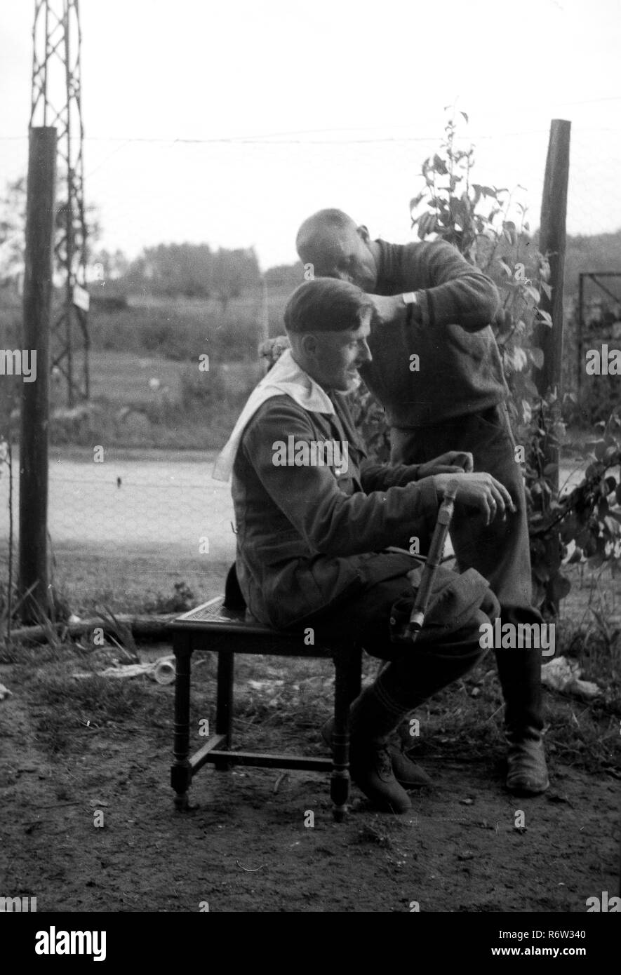 1940 soldats de l'armée allemande WW2 obtenir un style 'Hitler' couper les cheveux dans le nord de la France Banque D'Images