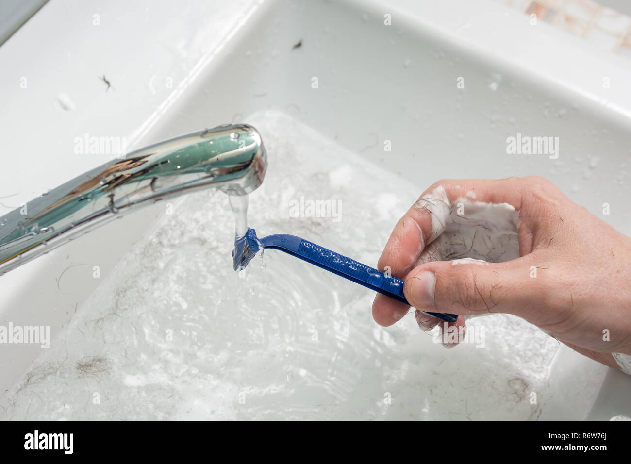 La main de l'homme lave le rasoir sous le jet d'eau, close-up sur le dessus  Photo Stock - Alamy