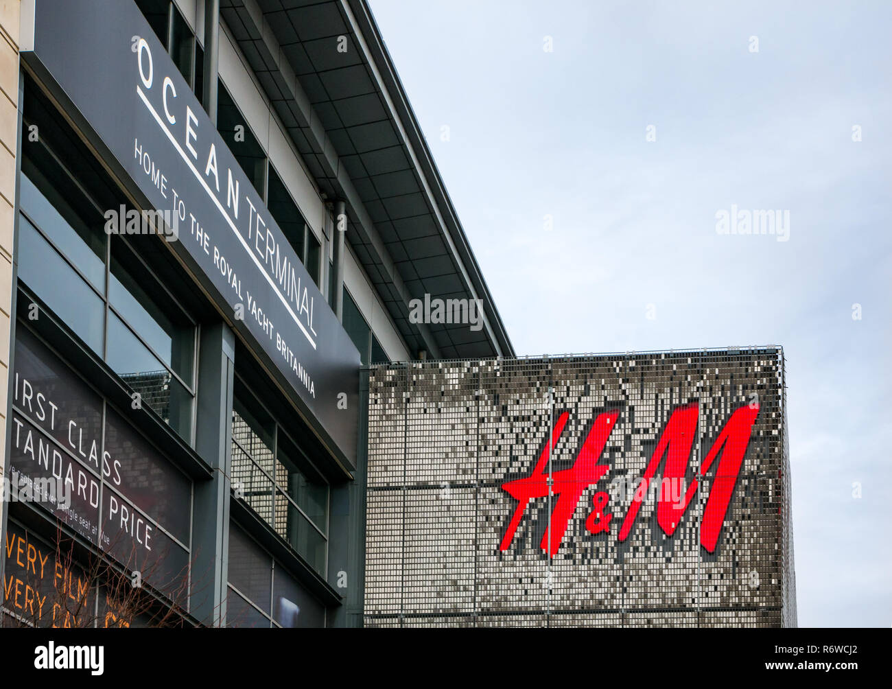 H&M magasin de vêtements de gros logo sur la construction de l'avant, centre commercial Ocean Terminal, Leith, Edinburgh, Ecosse, Royaume-Uni Banque D'Images