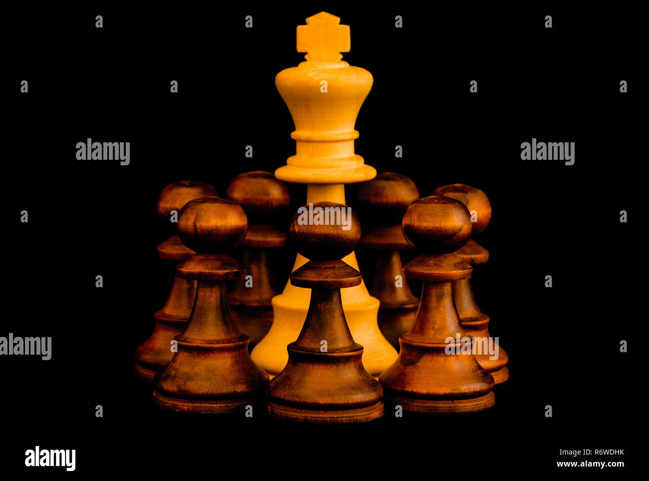 En état de siège. Roi blanc assailli par des ennemis avec le sens de no escape, échecs standards morceau en bois sur fond noir Banque D'Images