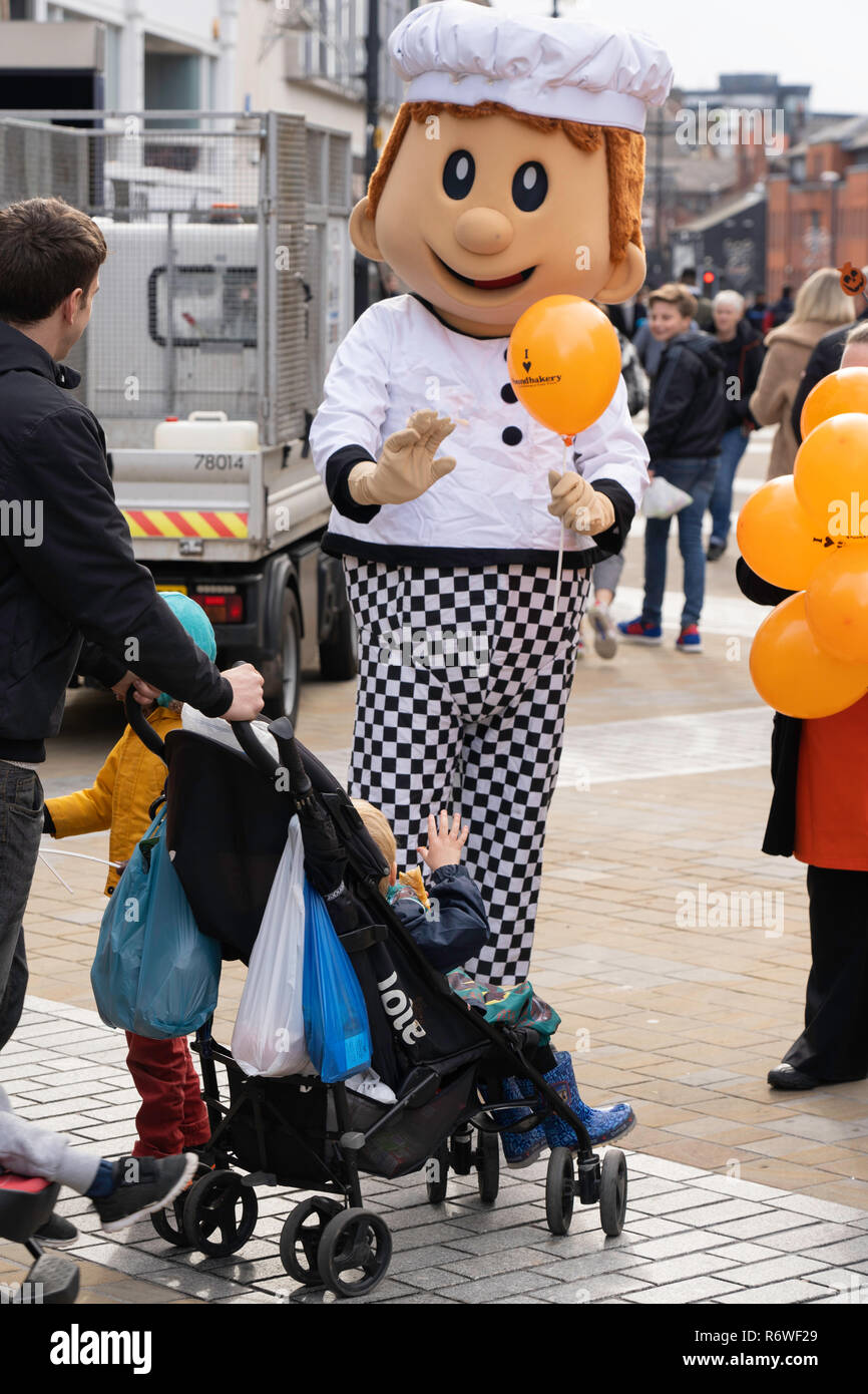 Boulangerie Mascot distribuant des ballons orange à Leeds, Briggate, West Yorkshire, Angleterre, Royaume-Uni. Banque D'Images