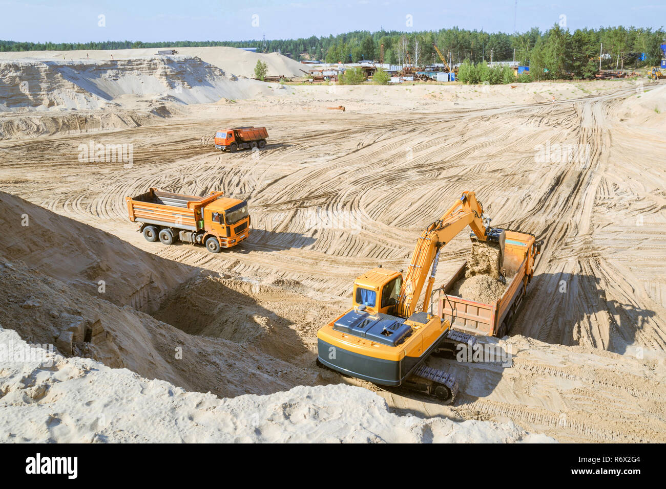 Travaux de l'excavatrices et camions lors d'une carrière de sable. Chargement de l'excavateur du sable dans un camion-benne. Banque D'Images