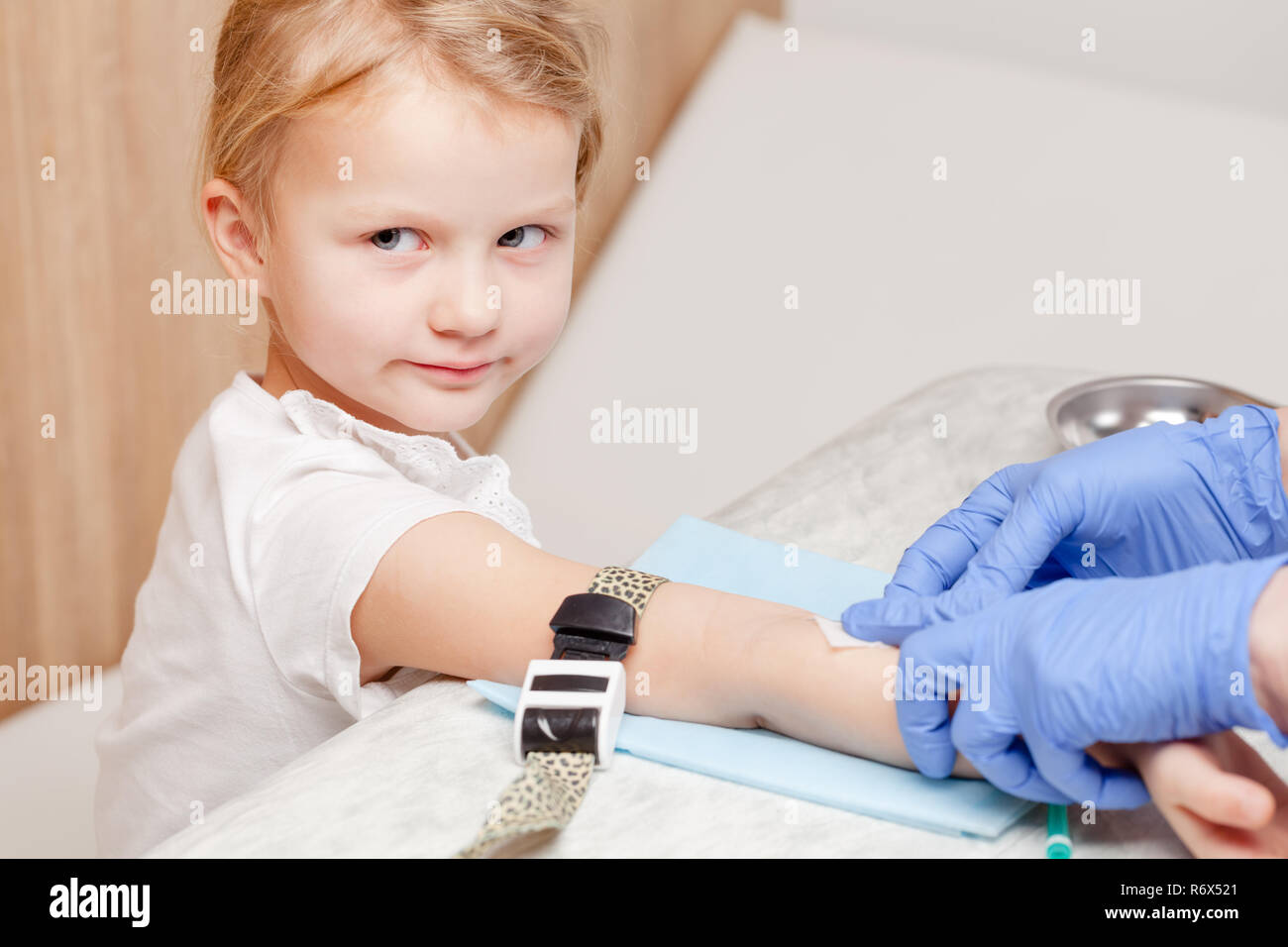 Médecin ou infirmière prêt à prendre un échantillon de sang de la petite fille avec une veine du bras vacutainer. La procédure de ponction veineuse ou ponction veineuse pédiatrique Banque D'Images