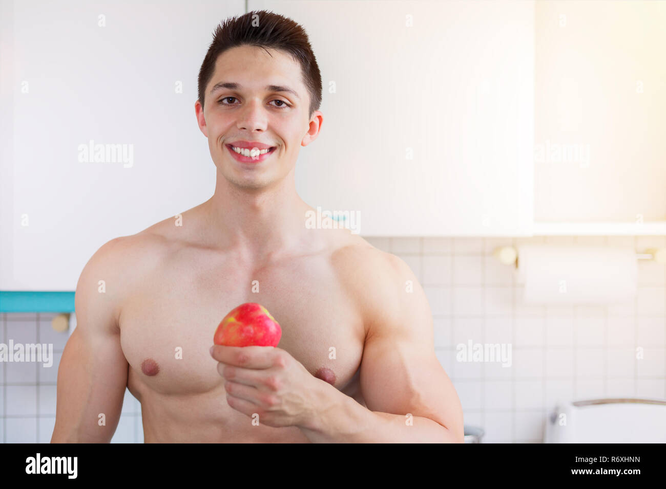 La saine alimentation jeune homme bodybuilder copie espace manger pomme fruit fruits dans la cuisine Banque D'Images