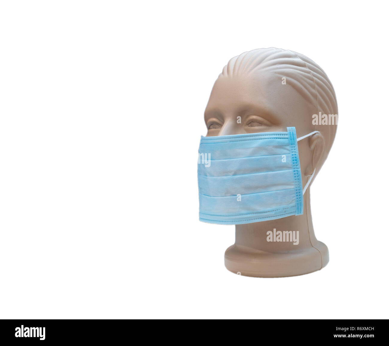 Masque médical sur un drôle de tête artificielle découpe isolé sur fond blanc avec beaucoup de copy space Banque D'Images
