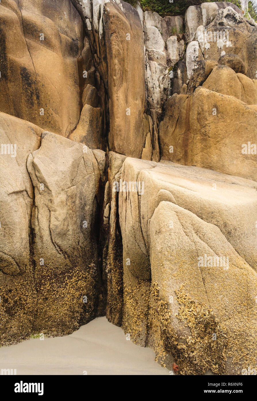 Résumé d'un gros plan de granit érodés bluff au bord d'une plage de sable fin, avec contraste dur, douce, lisse et rugueux de textures (Colombie-Britannique). Banque D'Images