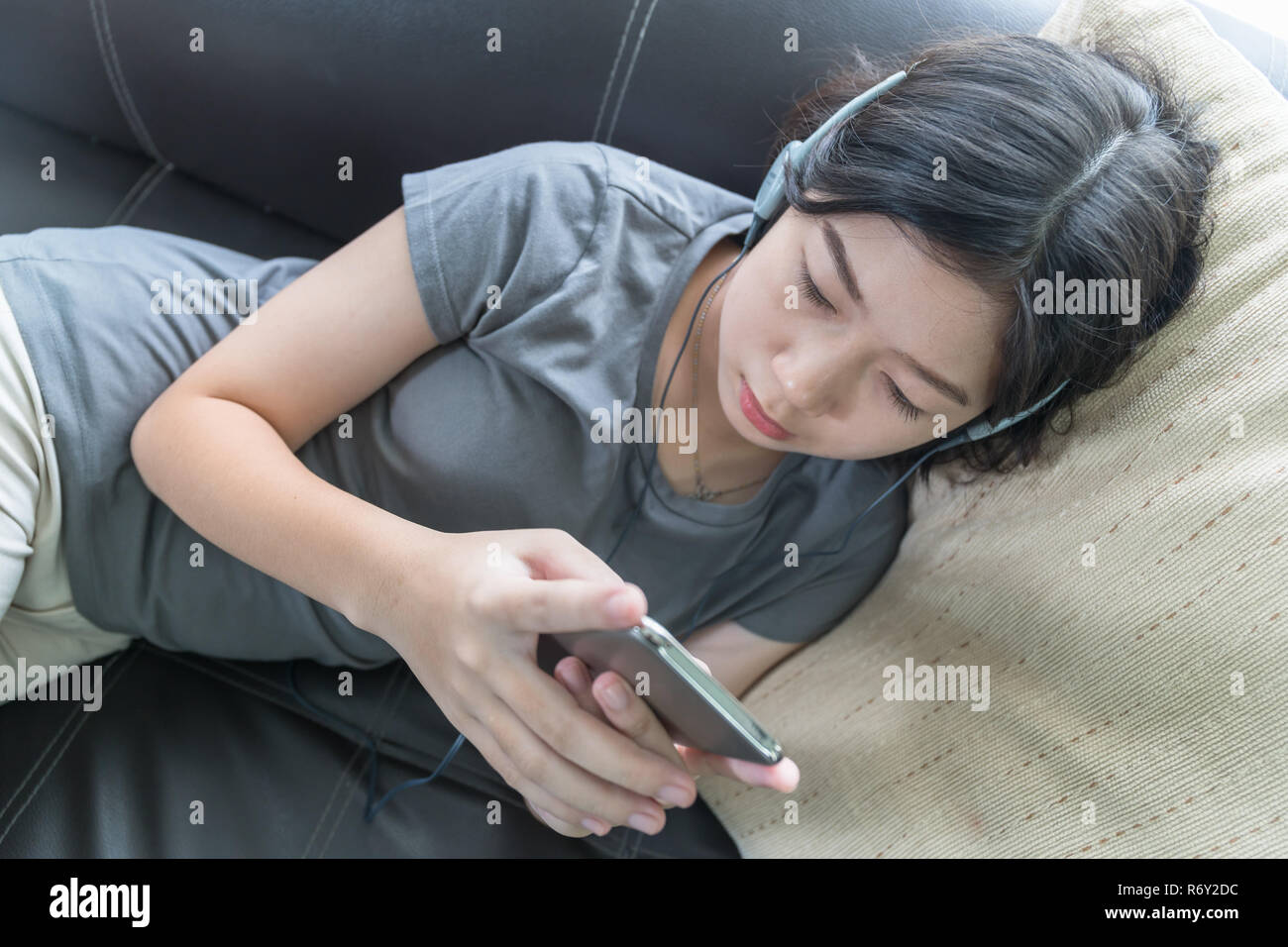 Asian woman listening music depuis un téléphone portable Banque D'Images