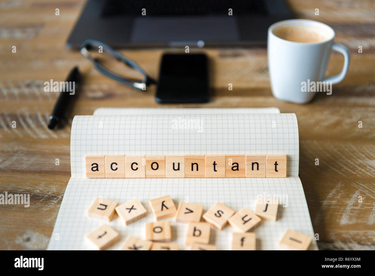 Gros plan sur ordinateur portable sur la table de bois, l'arrière-plan l'accent sur des pièces en bois avec des lettres formant des mots comptable Banque D'Images