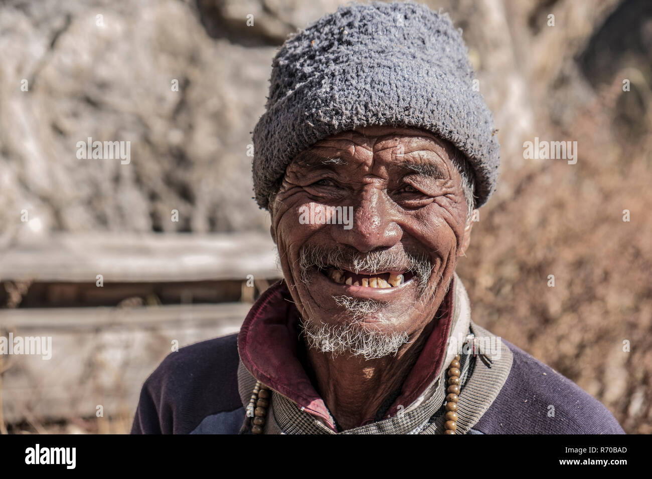 LANGTANG, NÉPAL- novembre 08, 2018 : Ancien homme de népalais Langtang valley avec visage ravagé qui pose pour la caméra. Banque D'Images