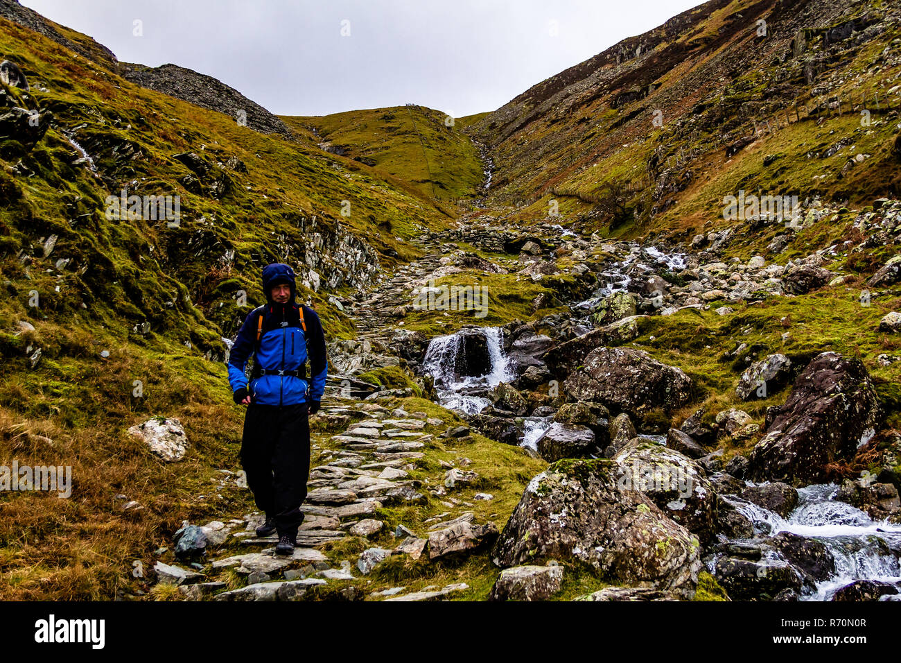 Un froid humide braves Walker de la Petite Venise, le Lake District, UK. La position de tête à Rosthwaite Dale. En décembre 2018. Banque D'Images