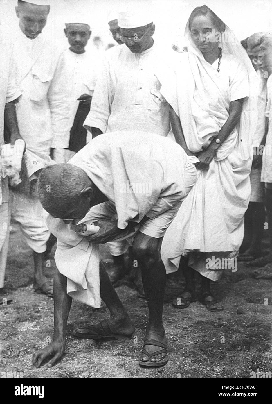 Mahatma Gandhi enfreignant la loi sur le sel en ramassant un morceau de sel naturel à Dandi, Gujarat, Inde, le 6 avril 1930, 8,30 heures vieux vintage photo des années 1900 Banque D'Images