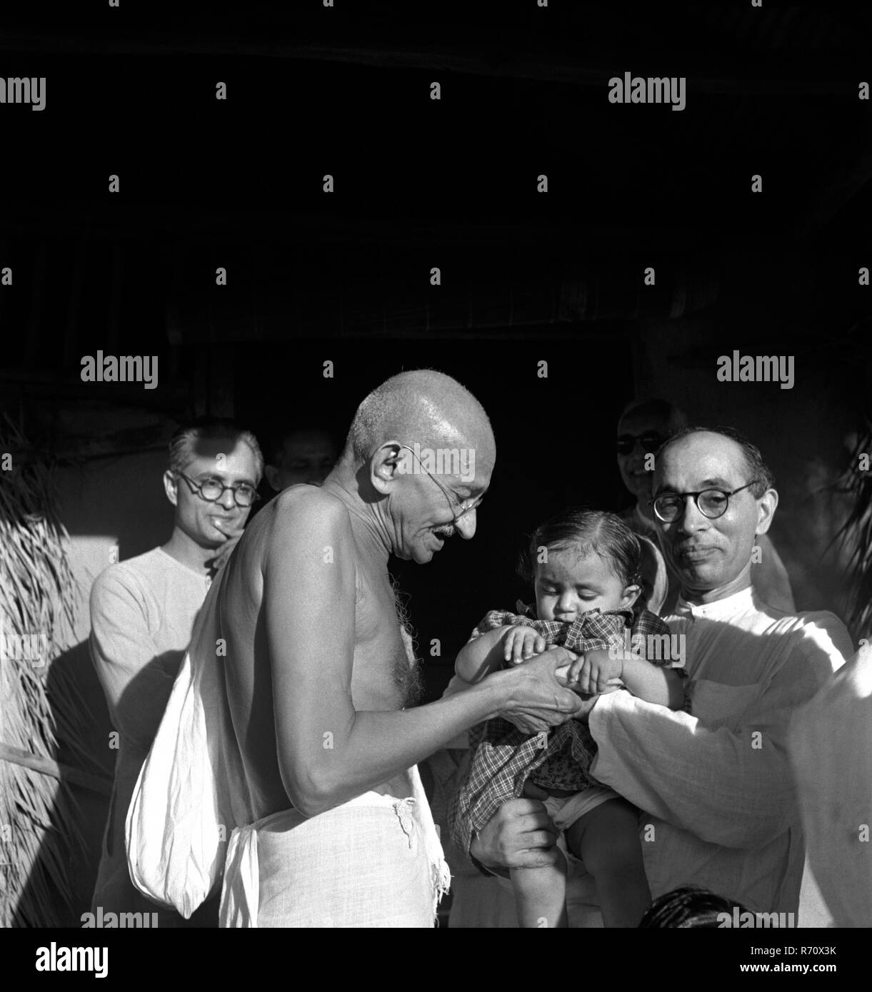 Mahatma Gandhi présente un cadeau d'anniversaire à Nandini, nièce de son secrétaire Pyarelal Nayar à Sebagram Ashram, Wardha, Inde, août 1944, ancienne image millésime 1900 Banque D'Images