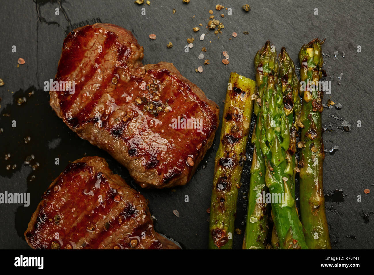 Close up boeuf grillé steaks sur plaque en ardoise noire Banque D'Images