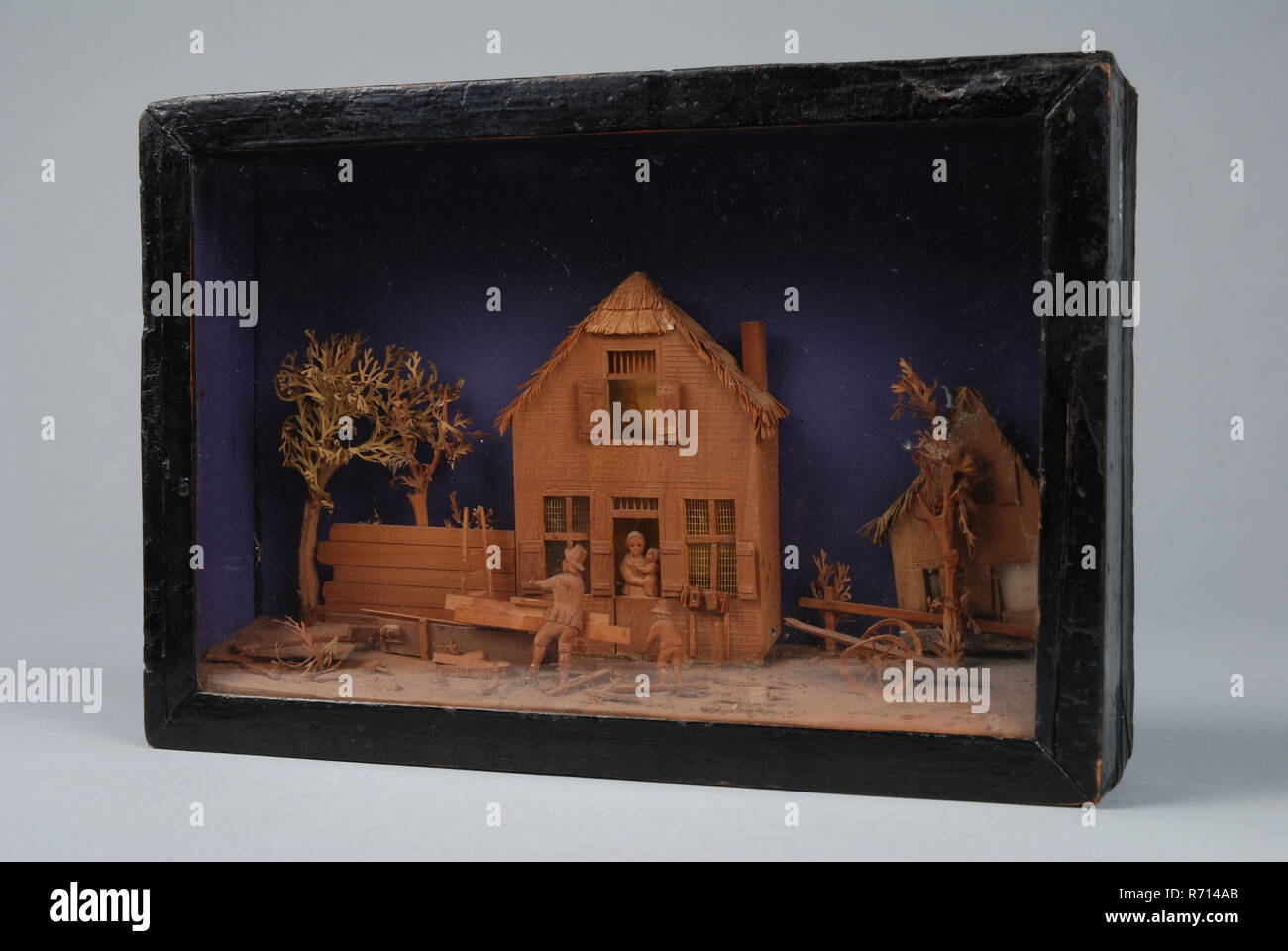 Bavelaar, petite boîte de visualisation avec scène de maison avec atelier de menuiserie, diorama avec papier de verre peinture bois carton, Bavelaar en carton de bois carton le papier et le verre. Théâtre de chambre avec clôture et arbres dans l'embrasure de la femme debout avec l'enfant en face de la maison du menuisier atelier : le charpentier est occupé du rabotage son fils regarde sur. Sur le terrain et d'un marteau sur le droit de rabotage panier derrière elle une autre chambre. Les branches des arbres et des toits de chaume sont en papier ; les autres pièces sont découpées dans du bois rouge-brun à grain fin. La note mauve décor probablement plus tard apposé optics di Banque D'Images Bavelaar, petite boîte de visualisation avec scène de maison avec atelier de menuiserie, diorama avec papier de verre peinture bois carton, Bavelaar en carton de bois carton le papier et le verre. Théâtre de chambre avec clôture et arbres dans l'embrasure de la femme debout avec l'enfant en face de la maison du menuisier atelier : le charpentier est occupé du rabotage son fils regarde sur. Sur le terrain et d'un marteau sur le droit de rabotage panier derrière elle une autre chambre. Les branches des arbres et des toits de chaume sont en papier ; les autres pièces sont découpées dans du bois rouge-brun à grain fin. La note mauve décor probablement plus tard apposé optics di Banque D'Images