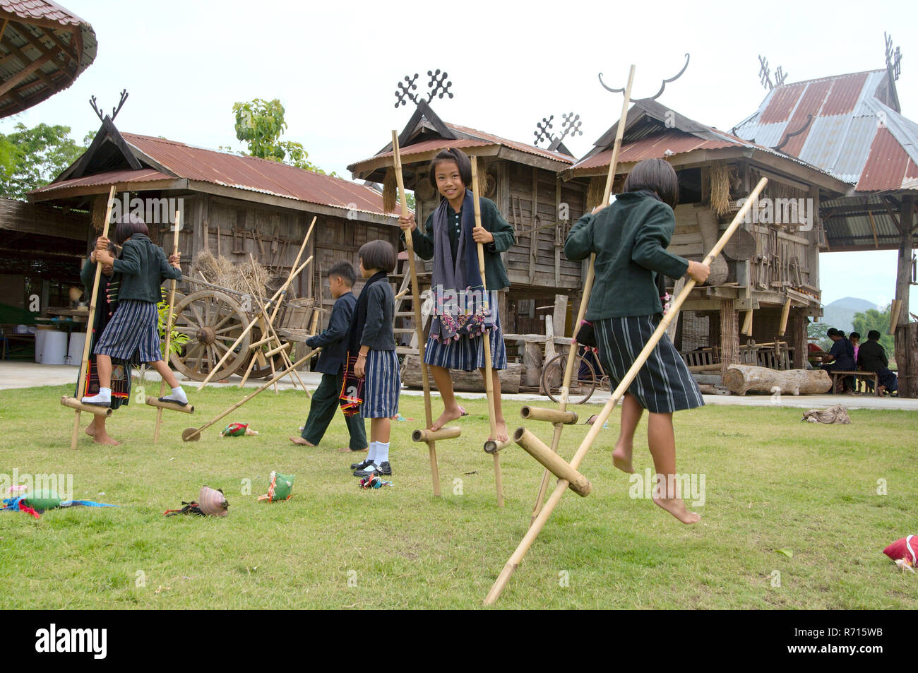 Tai Dam enfants marchant sur pilotis en bambou, province de Loei, Thaïlande Banque D'Images