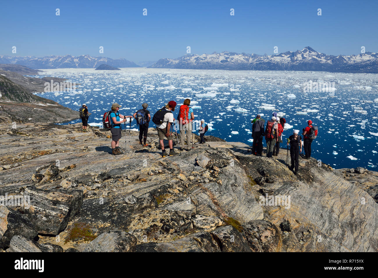 Groupe de personnes, randonneurs, surplombant le fjord Sermilik, Kalaallit Nunaat, le Groenland Banque D'Images