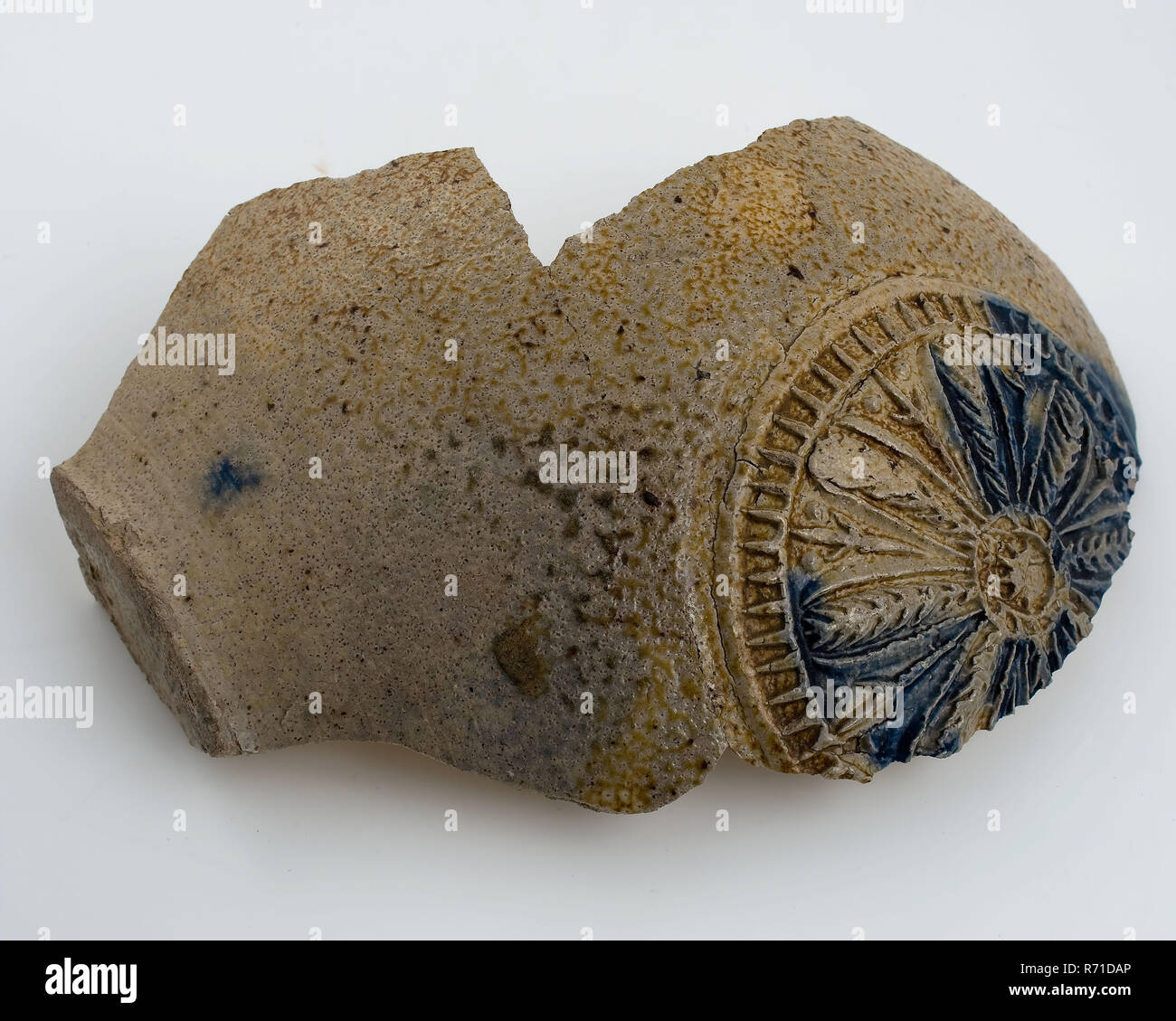 Fragment de l'abdomen de l'homme à barbe, grès, avec cartouche ronde qui beardmug en rosette, vaisselle en grès céramique trouver sol porteur glaze glaçure sel tournées à la main, émaillés grès cuits moulés le cachet du morceau de ventre rond ovale lumineux verseuse pot. Petit stand. Vitrage gris avec des points bruns. Cartouche en relief avec quelques coups de glaçure bleu cobalt dans le cartouche rosette de feuilles dans lequel huit huit épis de maïs bord cranté. Les verrous tournant à l'intérieur d'archéologie Voir la carte Présentation Stadsdriehoek Rotterdam métro Oostplein poterie étrangère fosse boisson boutique boutique d'importation de vin bière faites un don Tableau S Banque D'Images