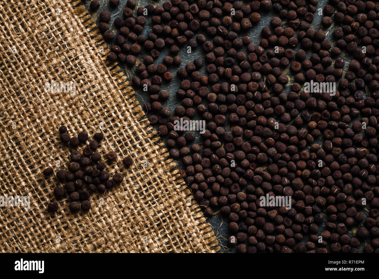Le poivre noir de poil sur tableau bleu et tissu jute Sheet Banque D'Images