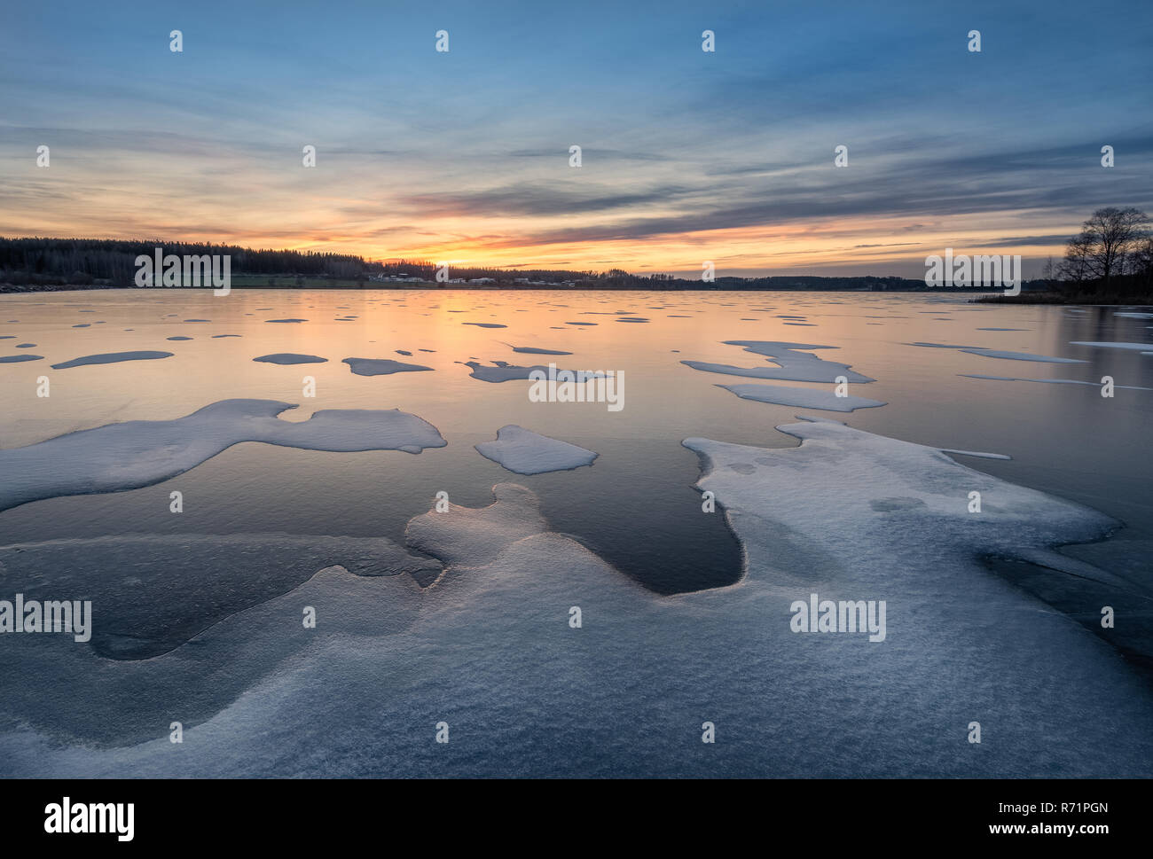Paysage d'hiver paysage avec lac gelé, coucher de soleil et belle lumière du soir en Finlande Banque D'Images