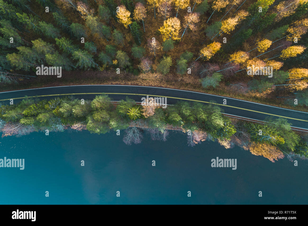 Voir ci-dessus de l'air d'une route par le lac et forêt d'automne, la Finlande Banque D'Images