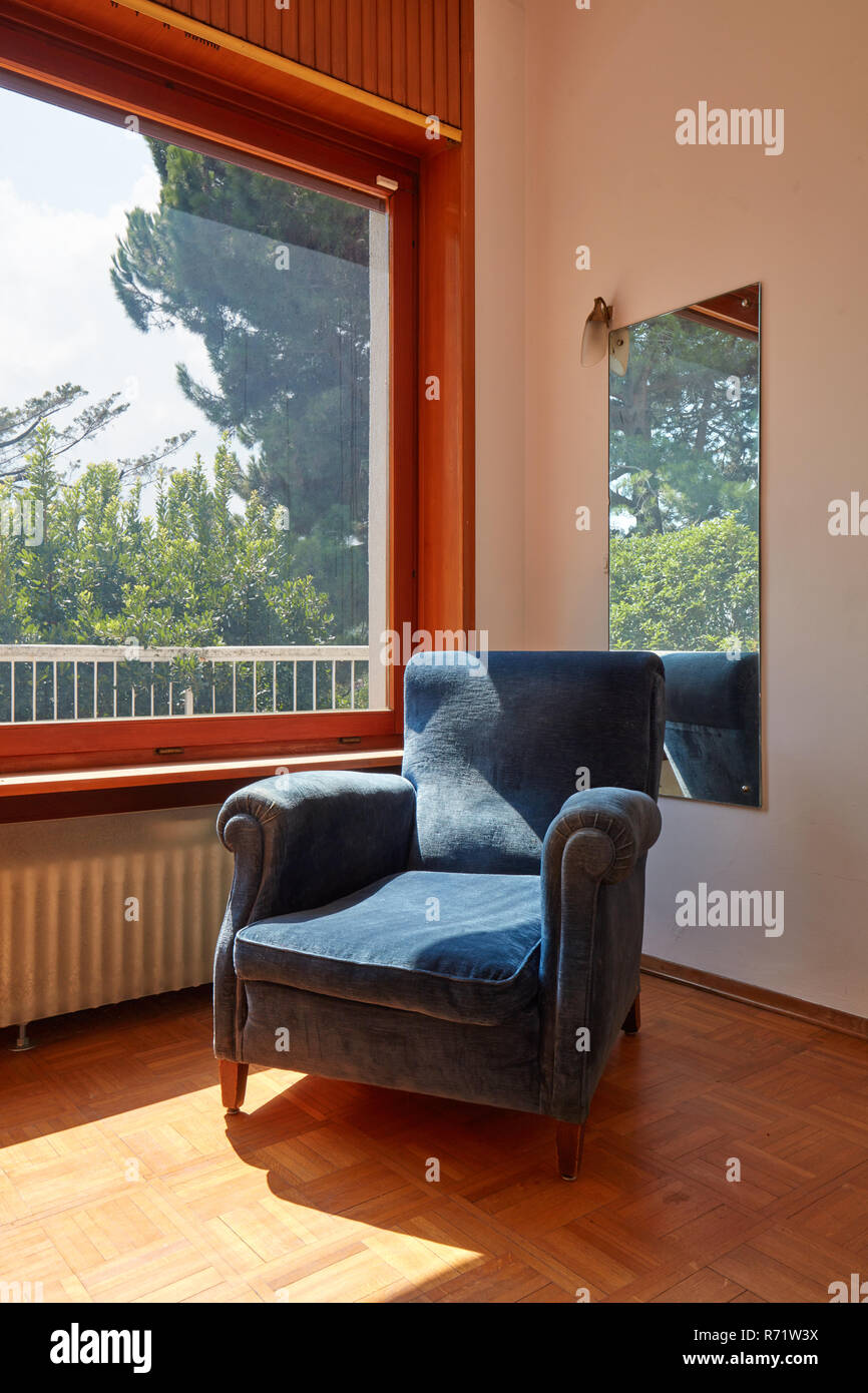 Fauteuil en velours bleu dans une chambre ensoleillée, maison de l'intérieur Banque D'Images
