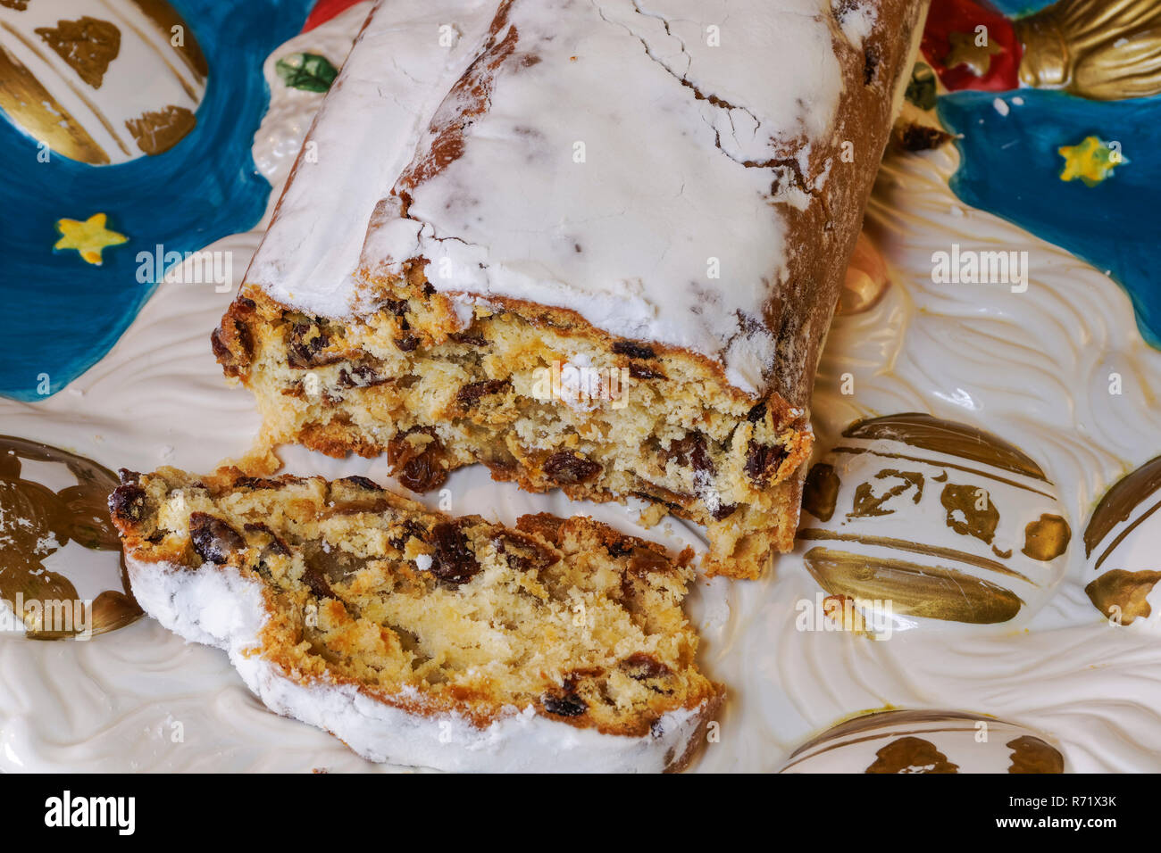Noël Stollen massepain allemand traditionnel gâteau sur un plat. Saison fruits pain aux noix, d'épices et de sucre en poudre avec une tranche coupée sur un plat. Banque D'Images