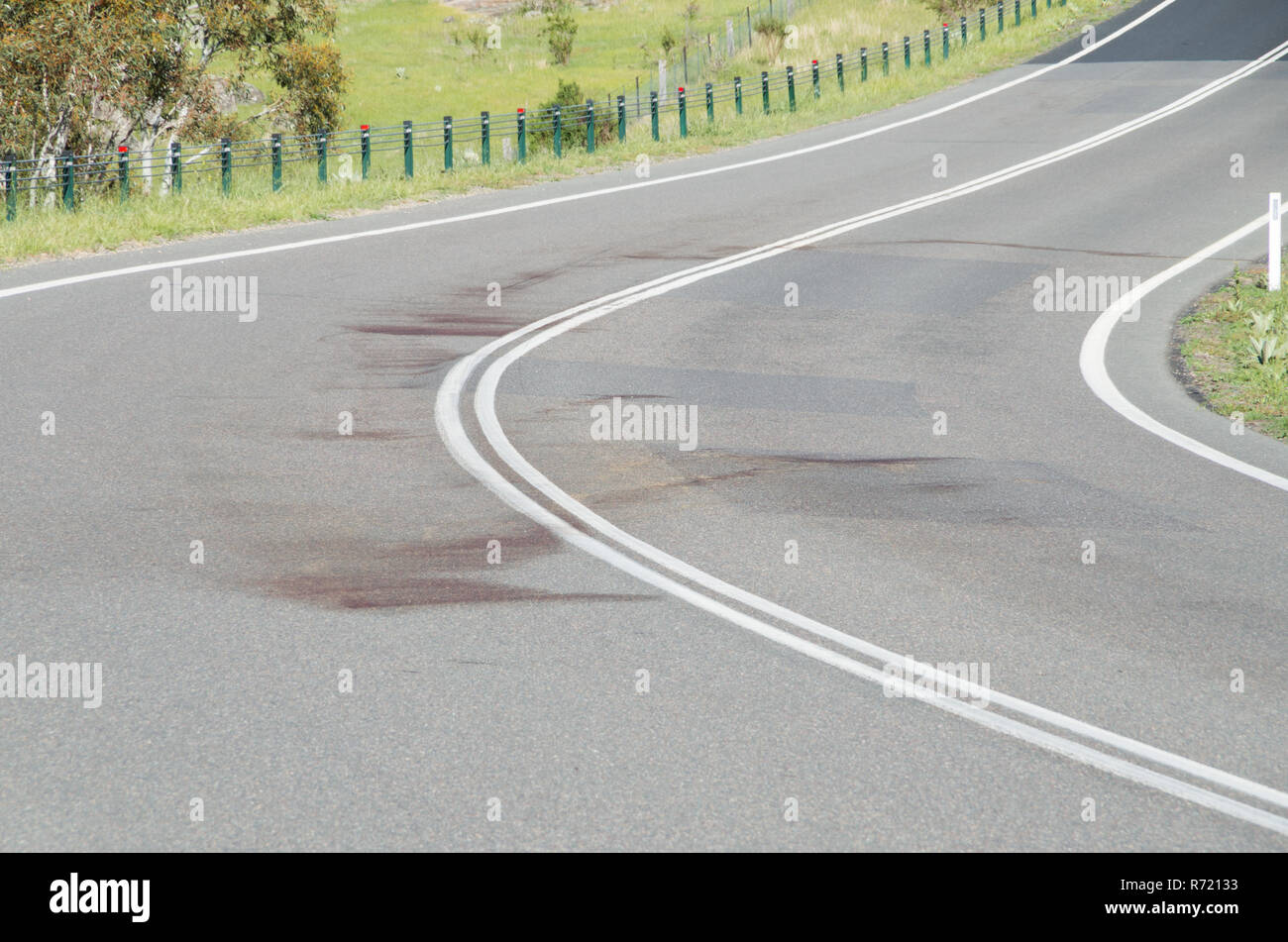Grande tache de sang sur un coin de route rurale après la faune a été frappé et tué pendant la nuit en Australie Banque D'Images