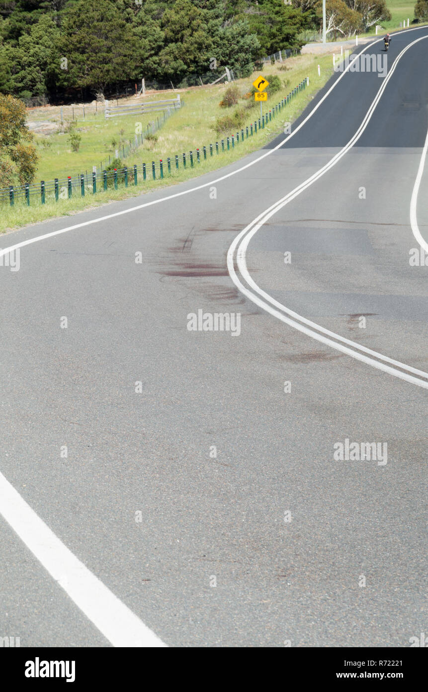 Grande tache de sang sur un coin de route rurale après la faune a été frappé et tué pendant la nuit en Australie Banque D'Images