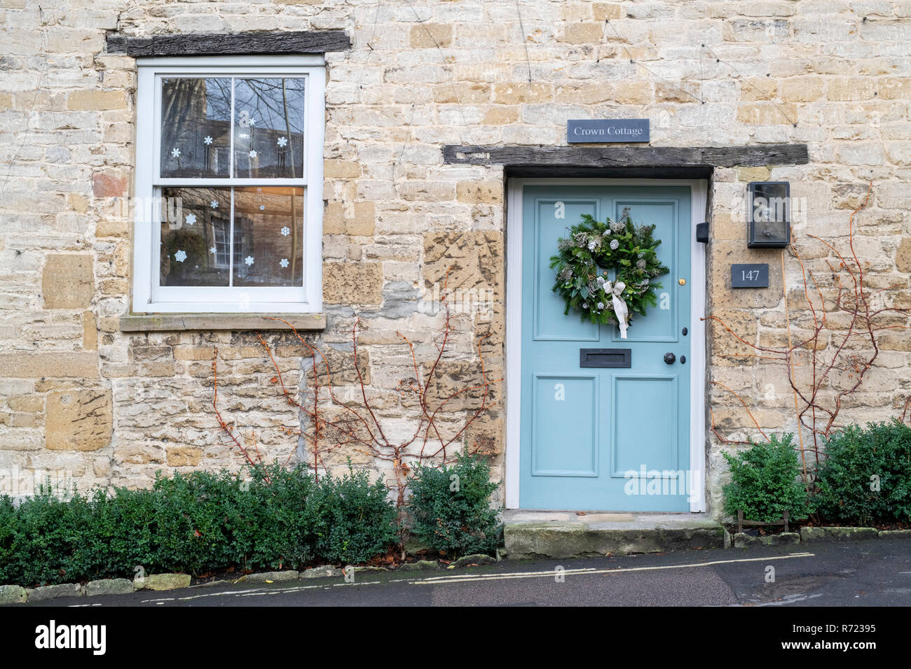 Couronne de Noël sur une porte du chalet à Burford. Cotswolds, Oxfordshire, Angleterre Banque D'Images