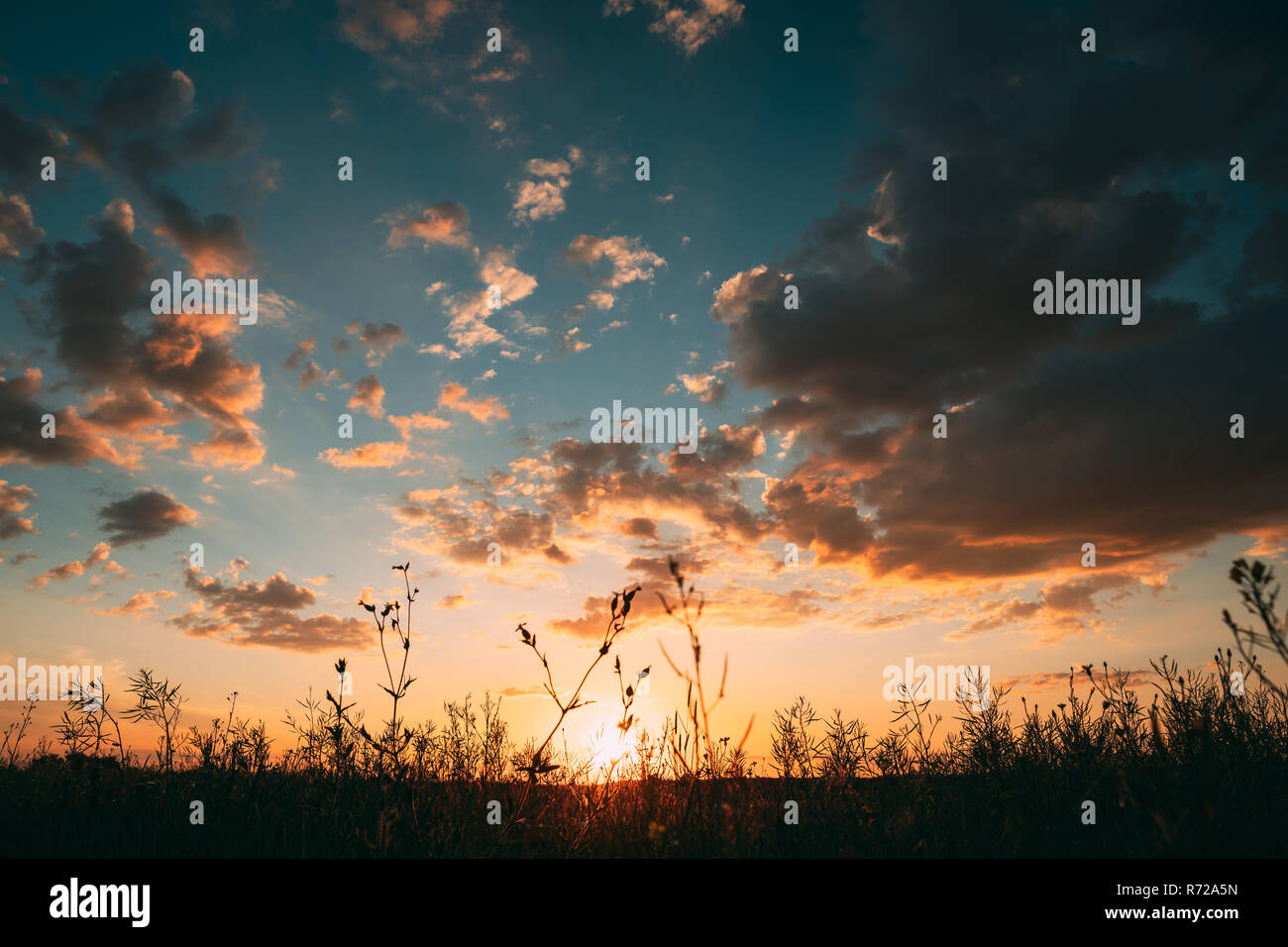 Soleil au coucher du soleil lever du soleil Ciel. Dramatique nuages ciel lumineux avec. Jaune, Orange, Bleu. La masse sombre et coloré aube du ciel. L'aube d'un ciel de couleurs vives Banque D'Images