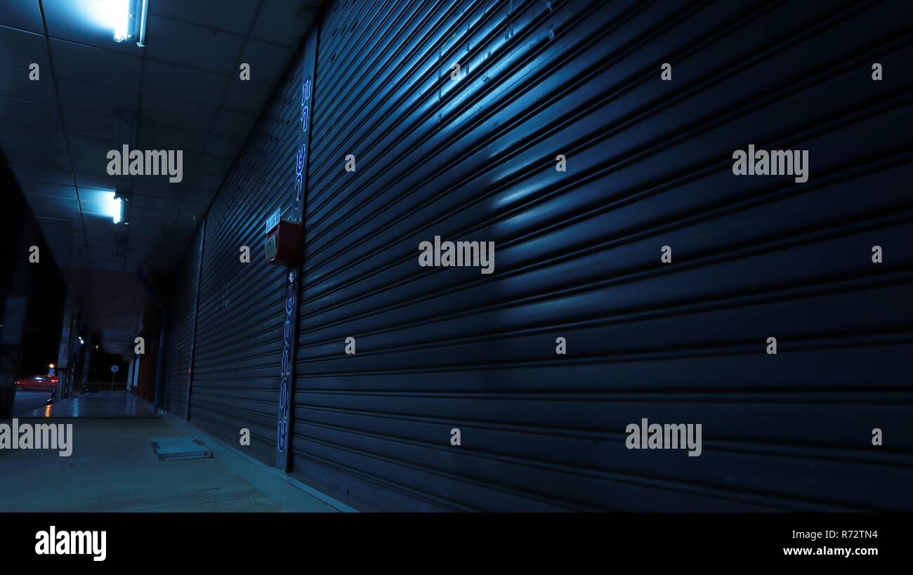 Scène de nuit de trottoir et de volets fermés allumé avec le plafond lumineux Banque D'Images