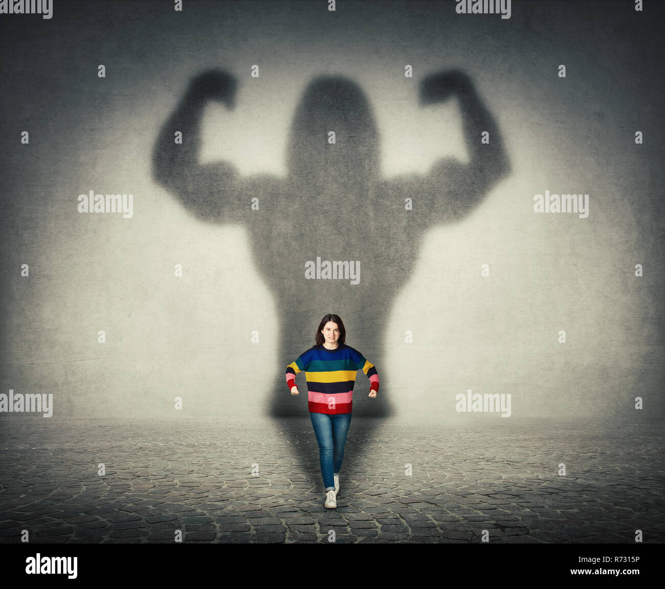 Confident businessman s'imaginer un puissant héros, d'ombre d'un bodybuilder musculaire montrant ses biceps. Force intérieure, de leadershi Banque D'Images