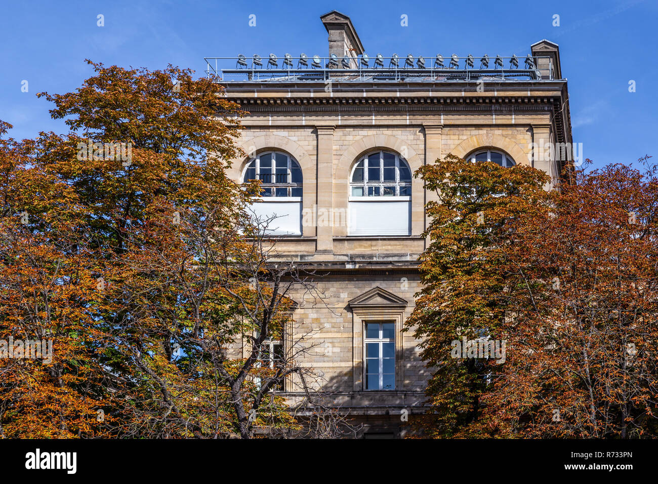 Bâtiment en brique générique en europe couvertes par orange leaf arbres en journée ensoleillée d'automne. Banque D'Images
