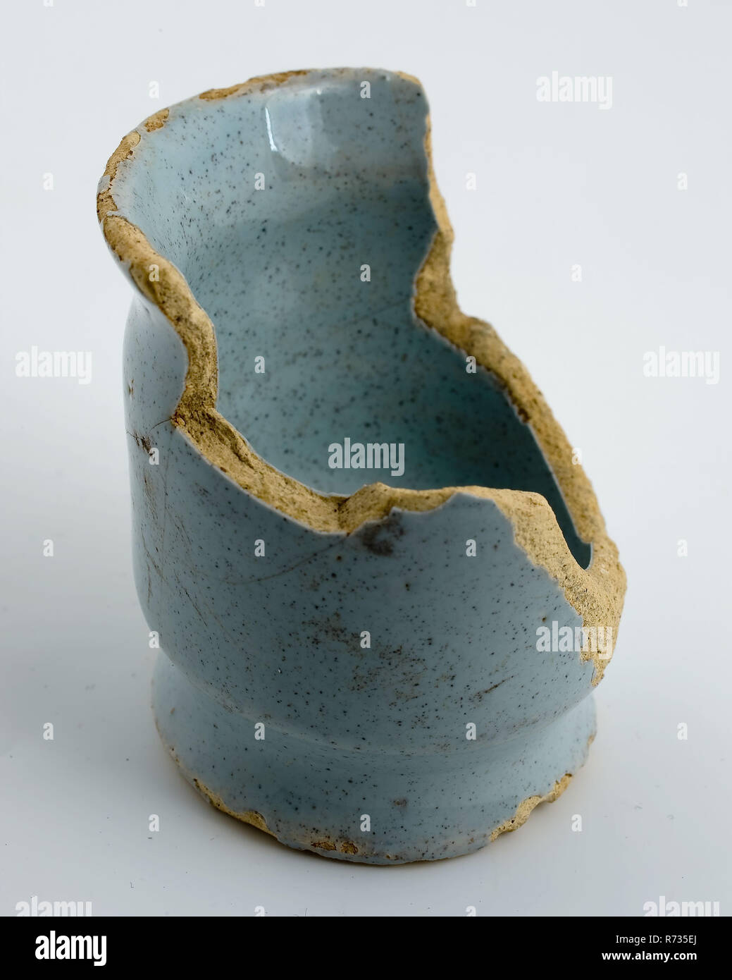 Fragment de poterie pommade pot avec deux contraintes, émaillés bleu-blanc, onguent porte-pot en faïence céramique trouver sol glaze glaçure d'étain à la main, cuits au four glacé tourné modèle haut pot de pommade ou de la faïence de Delft Deux impasses. Bord supérieur en forme d'entonnoir entièrement vitré, à l'exception de la partie inférieure de la partie inférieure. Glacis teinté bleu clair. Surface de stand avec des traces de soustraction d'archéologie de la ville de Rotterdam fosse souterraine Oostplein Triangle autochtones de soins de santé médicaments médicaments pommade emballage poterie care pharmacy plaisance découverte du sol : métro Oostplein fosse couche sale à partir de 16061976. Banque D'Images