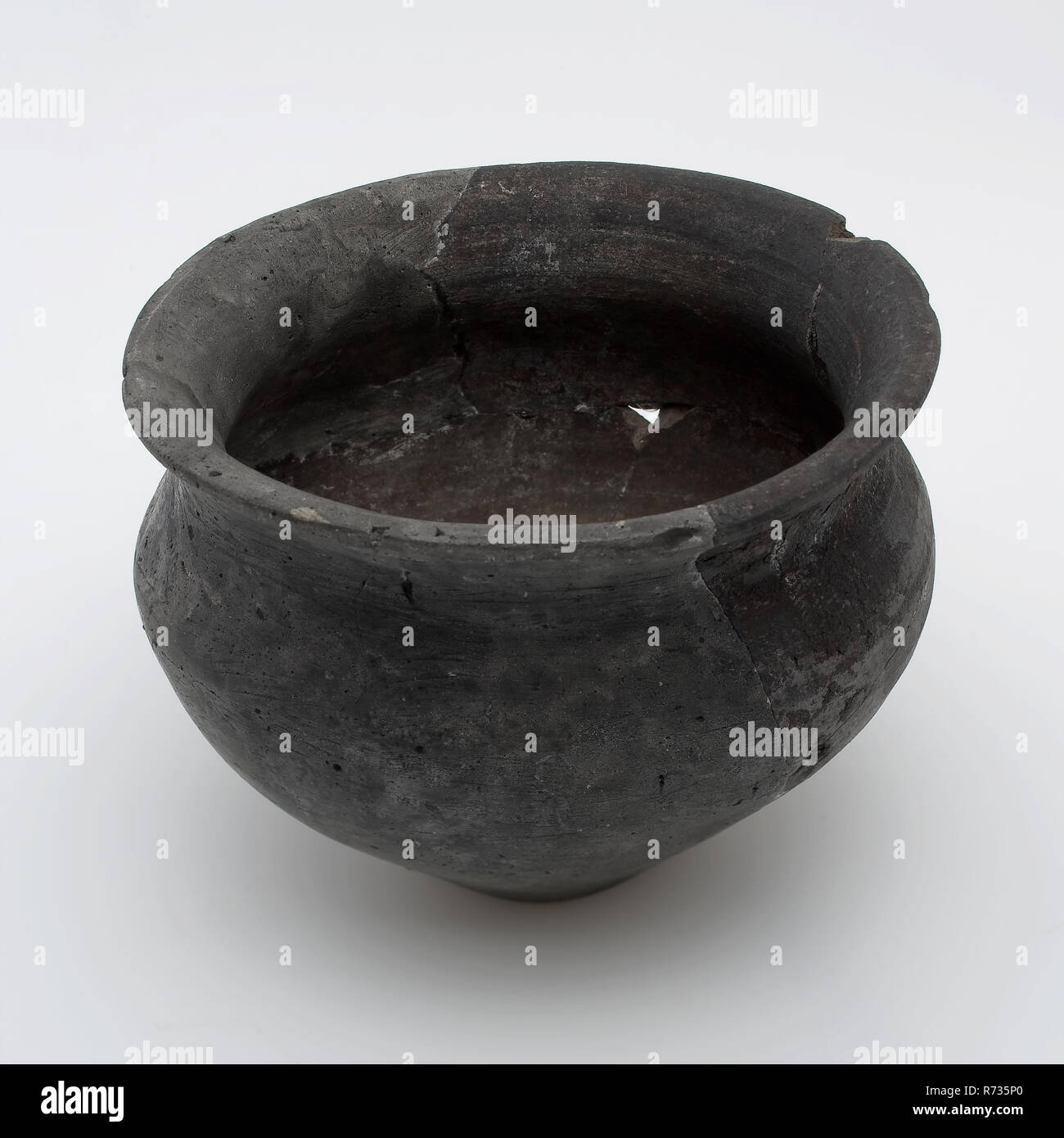 Petit pot noir sur socle étroit, de forme balustre, terra nigra, la poterie romaine, porte-pot en céramique, en terre cuite sols trouver main-devenu-pot de terre cuite au four noir romain. Terra Nigra. De forme balustre à col large avec pied étroit et profond sous l'encolure constriction archéologie Poortugaal Albrandswaard poterie indigènes servant d'importation servent cuisine cuisine découverte du sol Poortugaal hofterrein coin journal sous la couche de bois 't'est de la maison. Banque D'Images