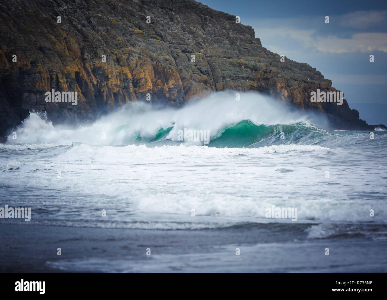 Au cours de l'onde d'un gros swell, près de la roche sur Ceiriad Porth beach, près de Abersoch, Pays de Galles, Royaume-Uni Banque D'Images