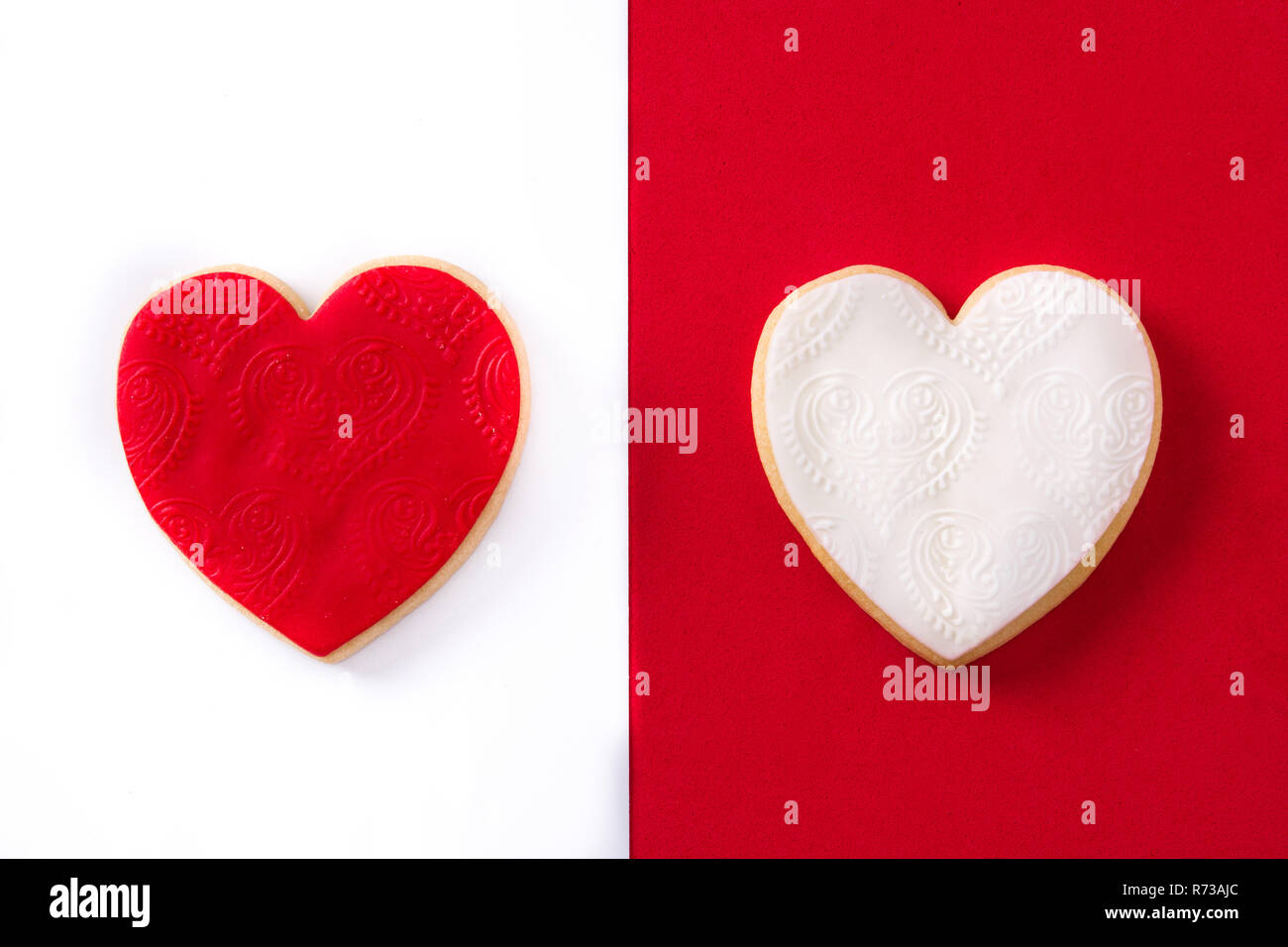 En forme de coeur rouge et les cookies pour la Saint-Valentin sur fond rouge et blanc. Banque D'Images