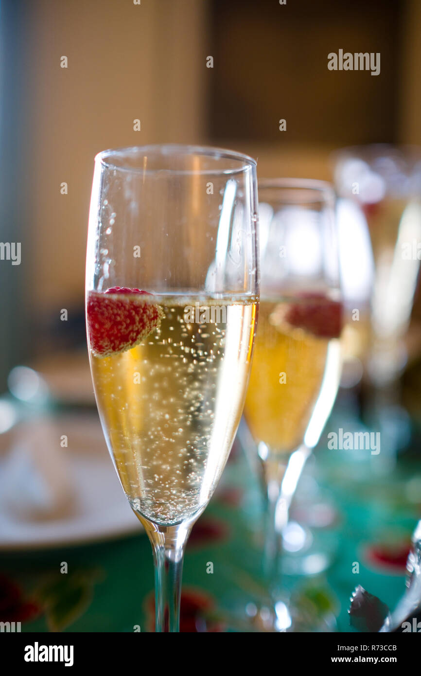 Près de l'atmosphère des verres de champagne avec champagne et framboises flottante par les bulles dans les verres cannelés sur une table lors d'action de grâce Banque D'Images
