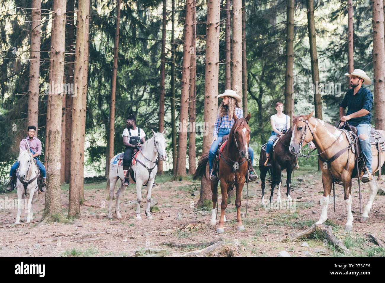 Cinq jeunes adultes l'équitation en forêt, Primaluna, Trentino-Alto Adige, Italie Banque D'Images