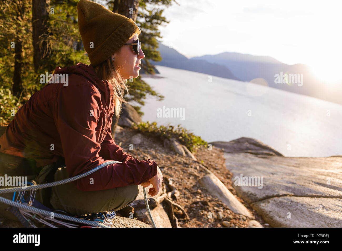 Rock climber appréciant le coucher du soleil le Malamute, Squamish, Canada Banque D'Images