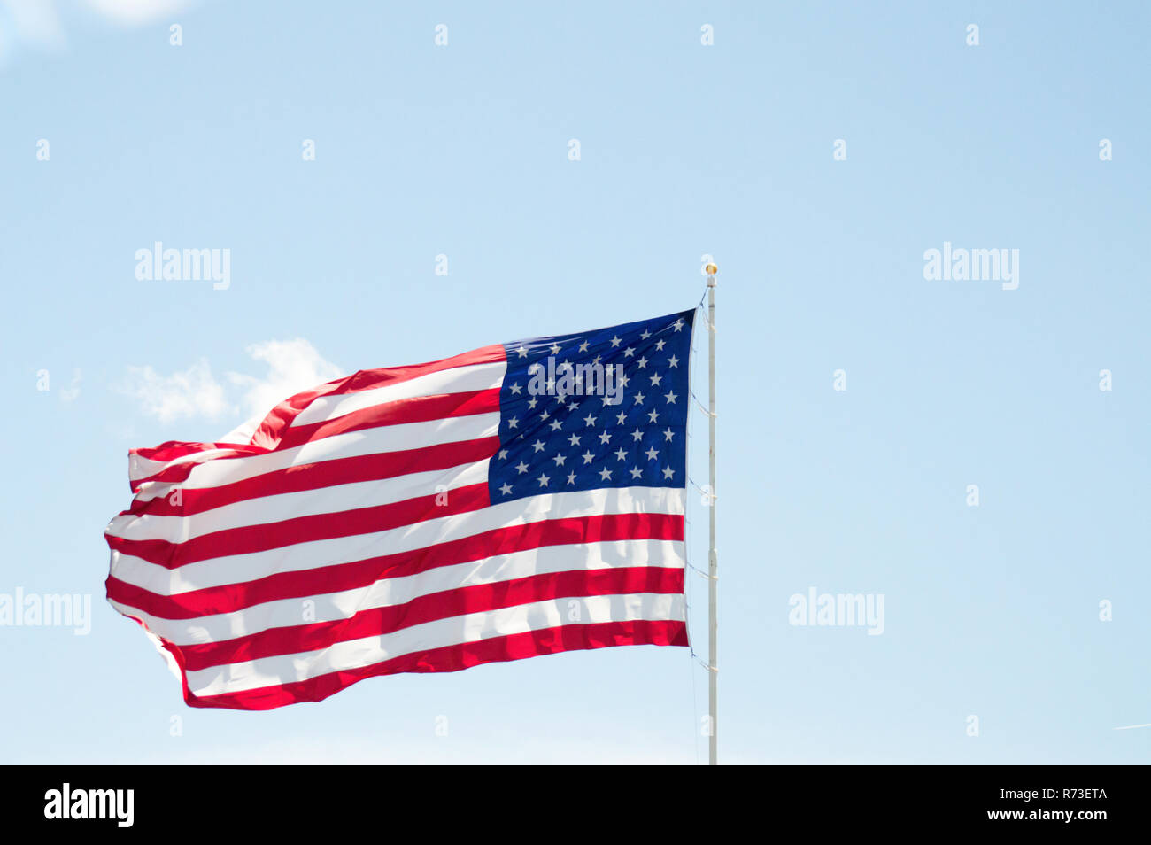 Un énorme drapeau américain voler dans un ciel bleu clair. Banque D'Images