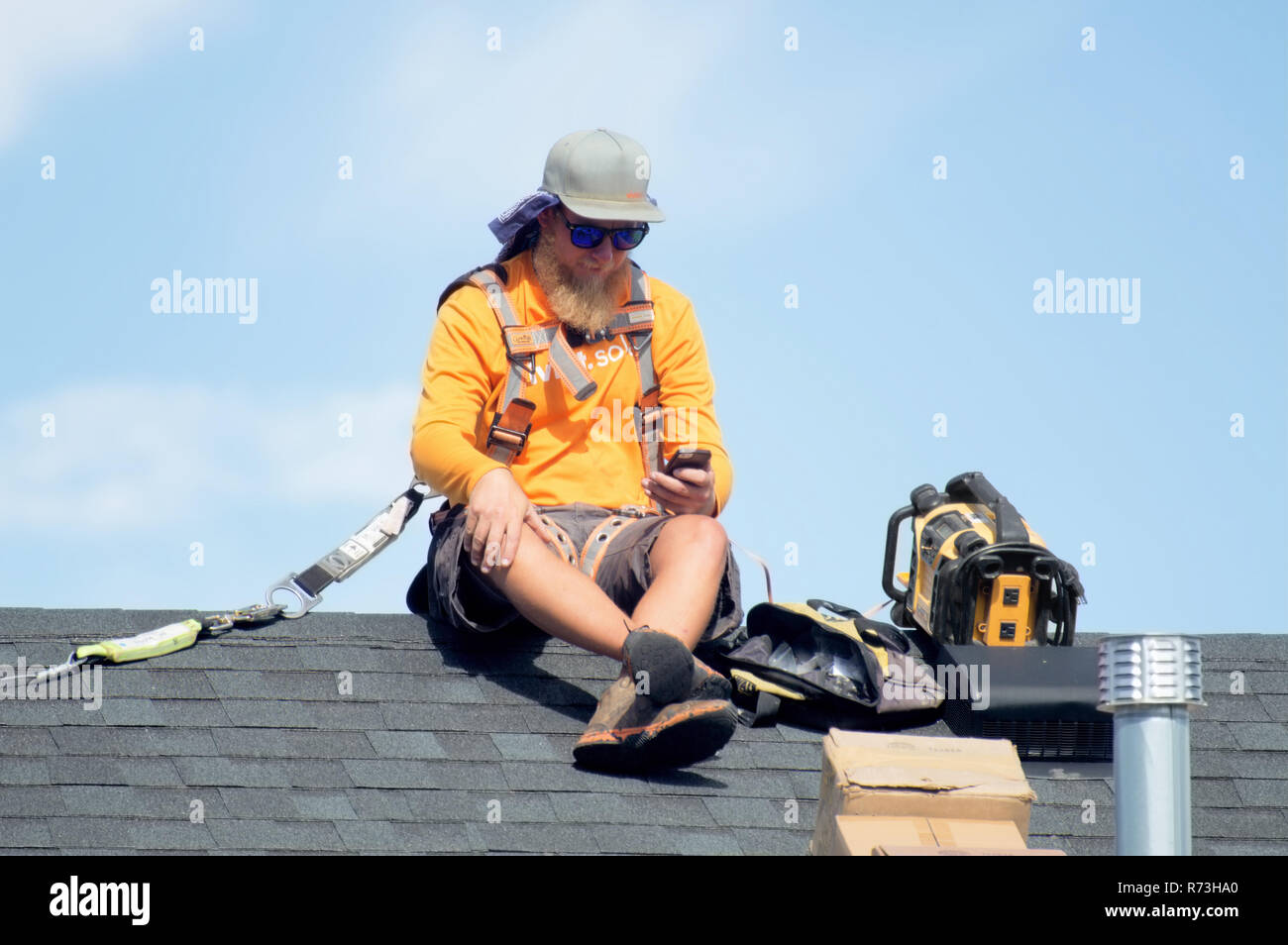 Les installateurs de panneaux solaires en faisant une pause sur le haut d'un toit. Banque D'Images