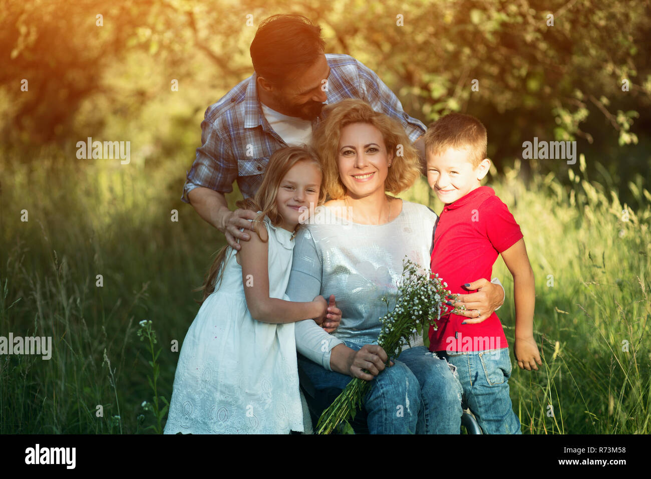 Jeune femme en fauteuil roulant avec sa famille. Portrait de famille Banque D'Images