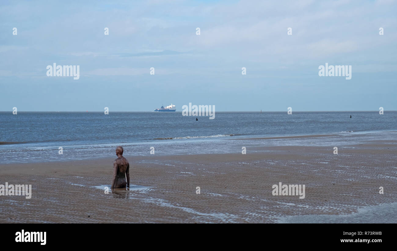 Crosby, Angleterre - le 6 novembre 2018 : un ferry au large de la plage en Amérique du Liverpool qui accueille une installation artistique par Anthony Gormley connu comme un autre lieu Banque D'Images