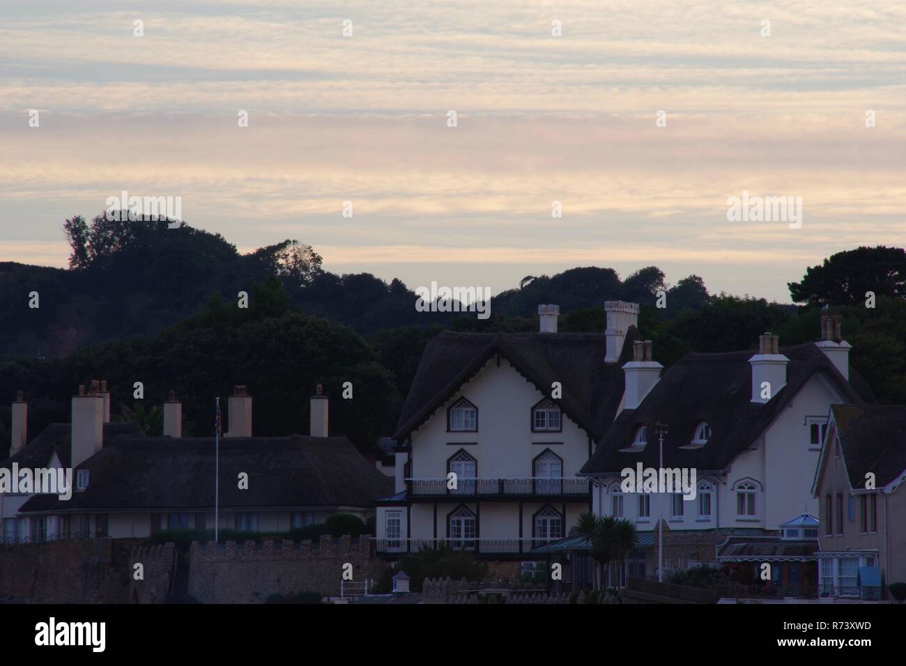 Et Rock Cottage front de chaume Lodge Chalets sur un coucher de soleil d'été. La ville de Sidmouth, l'est du Devon, Royaume-Uni. Banque D'Images