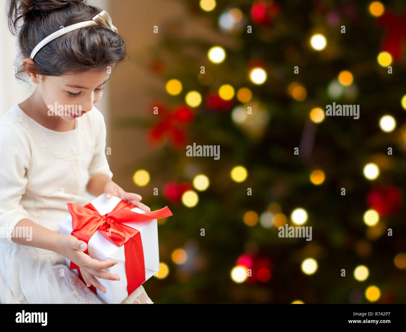 Happy little girl avec cadeau de Noël à la maison Banque D'Images